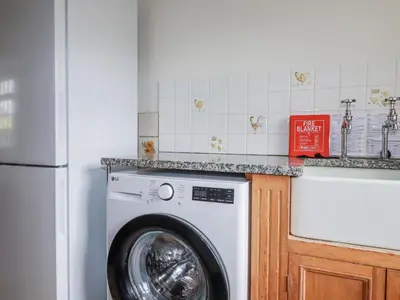 a washing machine in a kitchen next to a sink at Tresarrett Manor in Bodmin
