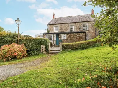 an old stone house with a blue door on a hill at Tresarrett Manor in Bodmin
