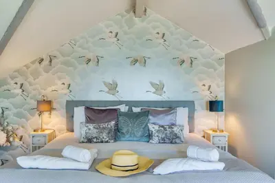 a bedroom with a bed with birds on the wall at Lightkeepers Cottage in Charlestown