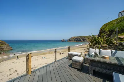 a wooden deck with a view of the beach at The Tide House in Portreath