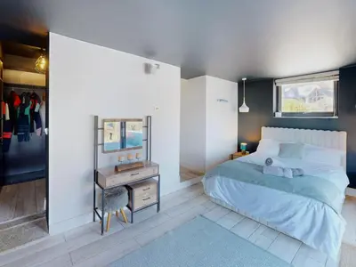 a bedroom with a bed and a table and a mirror at The Tide House in Portreath