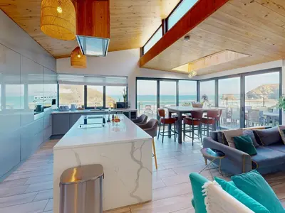 a kitchen and living room with a view of the ocean at The Tide House in Portreath