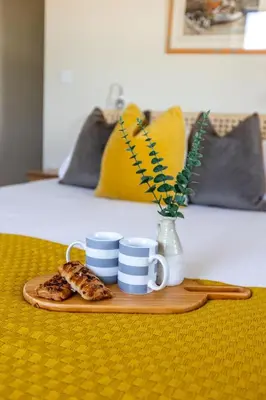 a tray with two cups and a plate of food at Sunset Sands in St Merryn