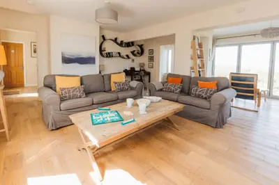 a living room with a couch and a coffee table at Sunset Sands in St Merryn