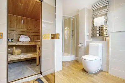 a bathroom with a toilet and a shower at Tranquil Shores in Carbis Bay