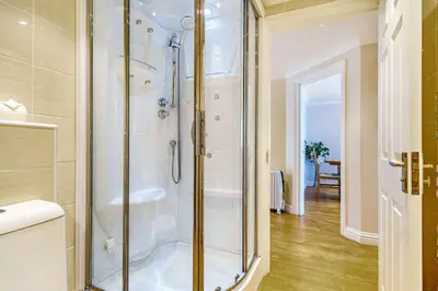 a bathroom with a shower with a glass door at Tranquil Shores in Carbis Bay
