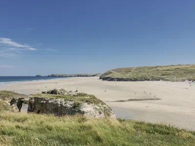 a beach with a bunch of people on the sand at Teach Tra West in Perranporth