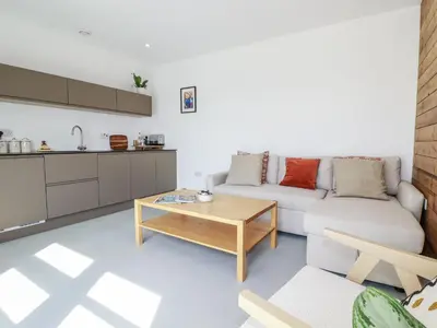 a living room with a couch and a table at Teach Tra East in Perranporth