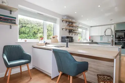 a kitchen with two chairs and a large counter at Hilbre in Padstow