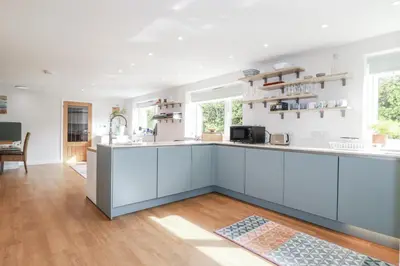 a kitchen with white cabinets and a counter top at Hilbre in Padstow