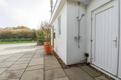 a white building with a door and a courtyard at Hilbre in Padstow