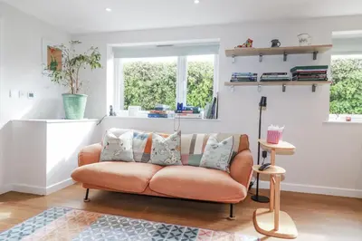 a living room with a couch and a window at Hilbre in Padstow
