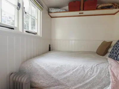 a bedroom with a bed in a room with windows at Hilbre Shepherd Hut in Padstow