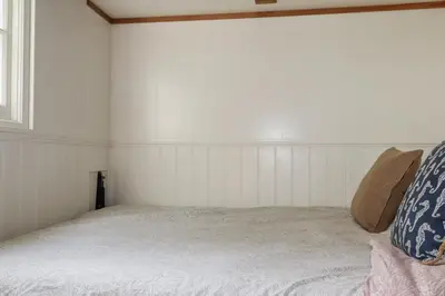 a white room with a bed and a window at Hilbre Shepherd Hut in Padstow