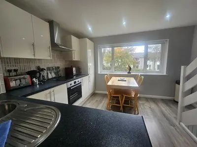 a kitchen with a table and chairs and a window at Newquay Coast and Cabin in Saint Columb Road Station