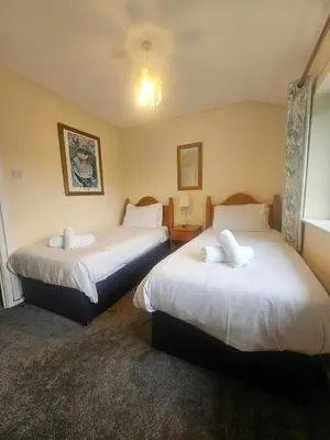 a hotel room with two beds and a window at Newquay Coast and Cabin in Saint Columb Road Station