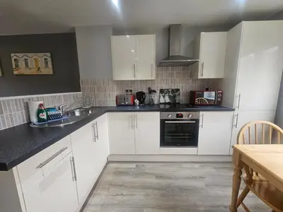 a kitchen with white cabinets and a stove top oven at Newquay Coast and Cabin in Saint Columb Road Station