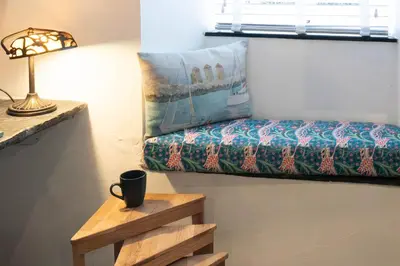 a room with a bed and a lamp and a table at Klys cottage in Saint Breward
