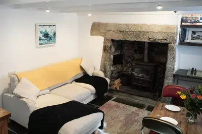 a living room with a couch and a fireplace at Klys cottage in Saint Breward