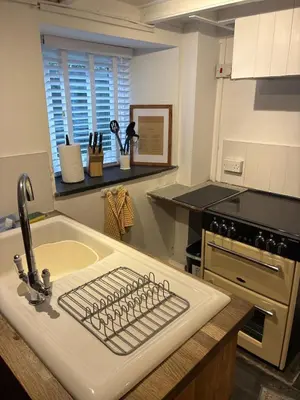 a kitchen with a sink with a keyboard on it at Klys cottage in Saint Breward