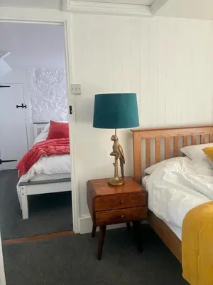 a bedroom with a bed and a lamp on a table at Klys cottage in Saint Breward