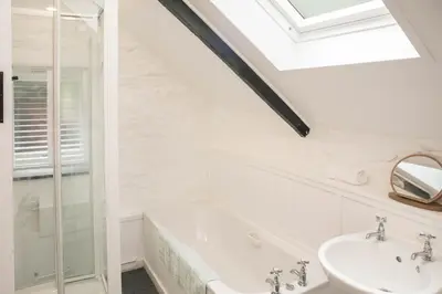 a bathroom with a sink and a bath tub at Klys cottage in Saint Breward