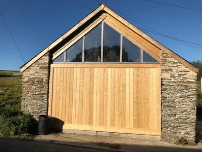 a wooden garage door with a large window at Little Tregue in Camelford