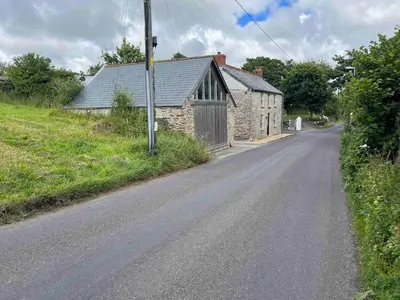 an empty road in front of a stone building at Little Tregue in Camelford