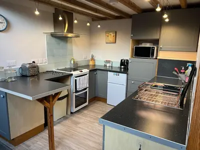 a large kitchen with a counter top and appliances at Little Tregue in Camelford