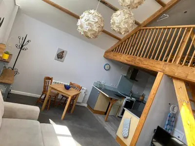 a living room with a staircase and a table at Little Tregue in Camelford
