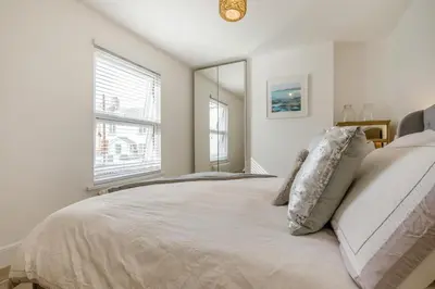 a white bedroom with a large bed and a window at 3 Bed in Padstow oc-f33036 in Padstow