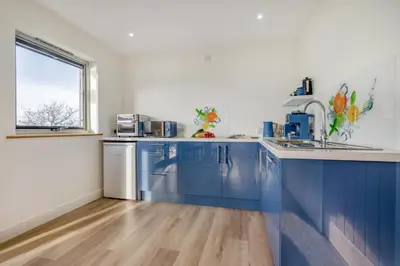 a kitchen with blue cabinets and a window at 2 Bed in Crackington Haven oc-h33817 in Crackington Haven