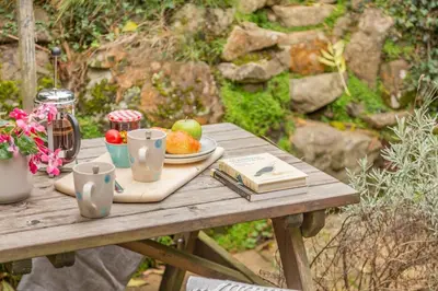 a wooden table with a plate of fruit on it at 2 Bed in St. Ives oc-g33644 in St Ives