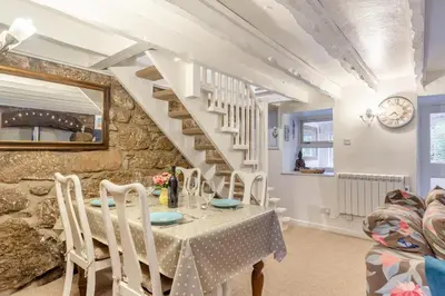 a dining room with a table and a stone wall at 2 Bed in St. Ives oc-g33644 in St Ives