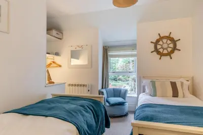 a bedroom with two beds and a clock on the wall at 2 Bed in St. Ives oc-g33644 in St Ives