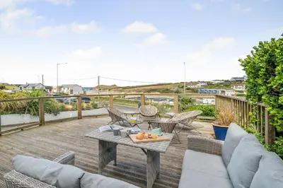 a patio with a table and chairs on a deck at 5 Bed in Newquay oc-c33035 in Newquay