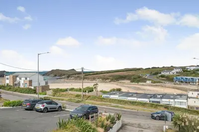 a parking lot with cars parked in front of a beach at 5 Bed in Newquay oc-c33035 in Newquay