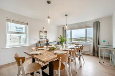 a kitchen and dining room with a wooden table and chairs at 5 Bed in Newquay oc-c33035 in Newquay