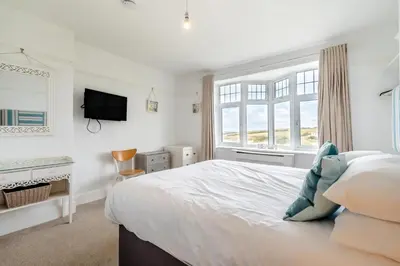 a white bedroom with a large bed and a window at 5 Bed in Newquay oc-c33035 in Newquay