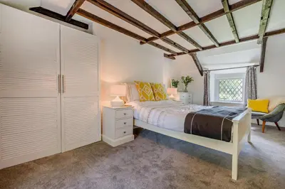 a bedroom with a bed and a chair and a window at 2 Bed in Advent oc-s6025 in Camelford
