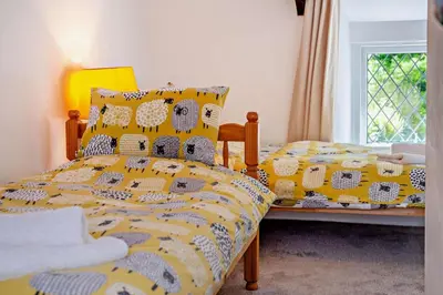 a bedroom with a bed with a yellow and white comforter at 2 Bed in Advent oc-s6025 in Camelford
