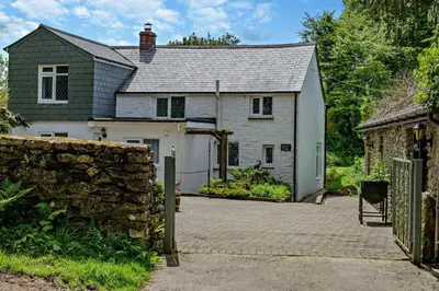 a white house with a gate and a stone wall at 2 Bed in Advent oc-s6025 in Camelford
