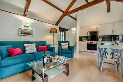 a living room with a blue couch and a table at 1 Bed in Advent oc-b29387 in Camelford