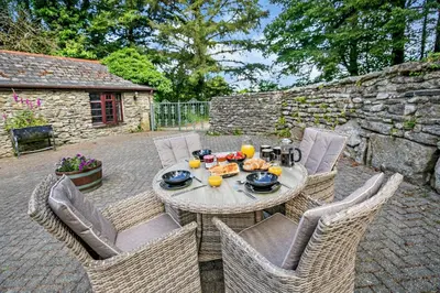 a patio with a table and chairs with food on it at 2 Bed in Advent oc-p6188 in Camelford