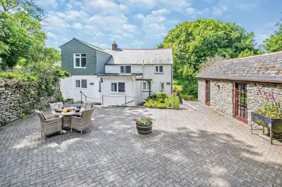 a patio with a table and chairs in front of a house at 2 Bed in Advent oc-p6188 in Camelford