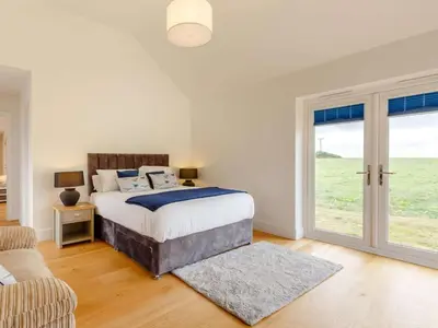 a bedroom with a bed and a sliding glass door at 3 Bed in Saltash oc-88525 in Landrake