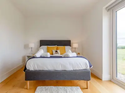 a bedroom with a large bed with yellow pillows at 3 Bed in Saltash oc-88525 in Landrake