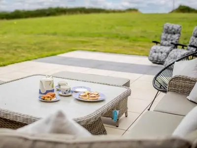 a table with two plates of food on a patio at 3 Bed in Saltash oc-88525 in Landrake