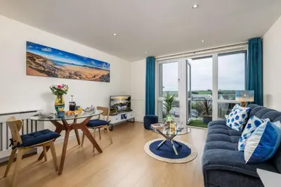 a living room with a blue couch and a table at 32 Tre Lowen in Newquay