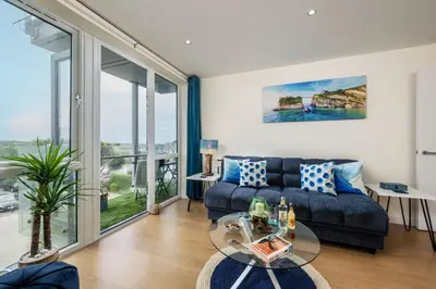 a living room with a couch and a glass table at 32 Tre Lowen in Newquay